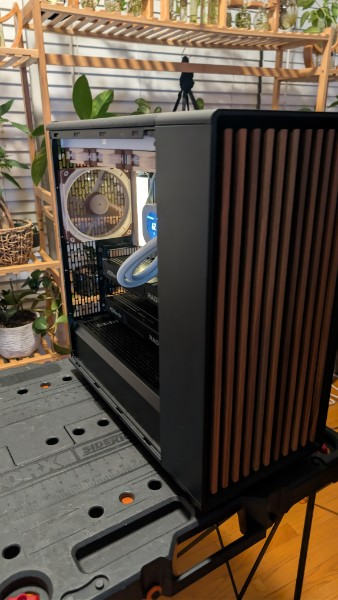 Three-quarter view of the AMD workstation with a wood-slat front panel and its open side visible.