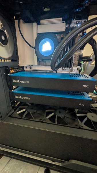 Two blue Intel Arc Pro B70 graphics cards inside an open workstation, above three case fans.