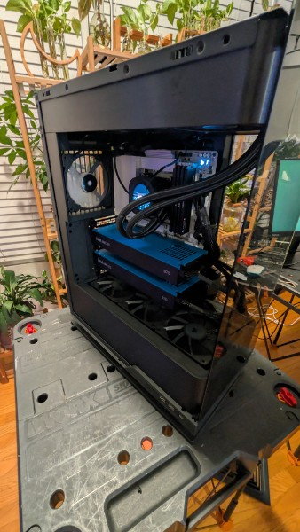 Open black Intel workstation case showing two blue graphics cards and liquid-cooling tubes.